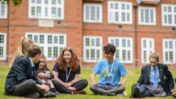 Pupils from The King's School Ottery sitting outside on the grass