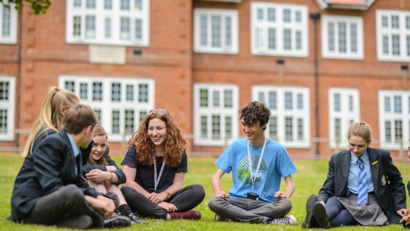 Pupils from The King's School Ottery sitting outside on the grass