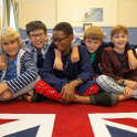 Boarders at Lockers Park School in their pyjamas, dressing gowns and sitting on a Union Flag rug