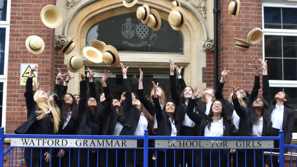 Pupils at Watford Grammar School for Girls toss their straw hats in the air.