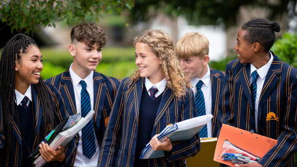 Colston's School pupils in uniform holding folders, books and stationary.