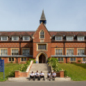 Pupils sitting in front of the main building at Cranleigh School