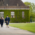 Pupils at Felsted School wearing gowns walk along school drive