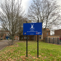 The school sign of Grey Coat School in Ham with the school buildings in the background