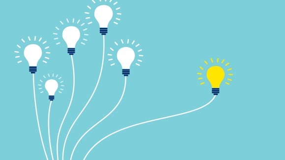 A lit lightbulb surrounded by others that have not been turned on