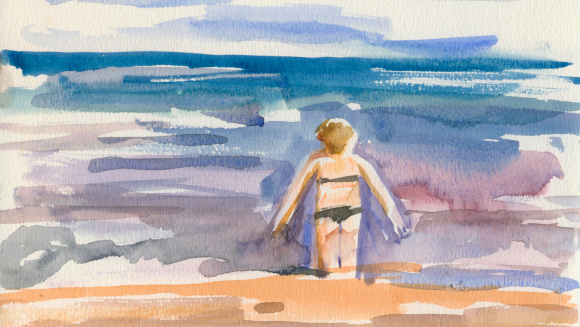 A woman wading into the sea