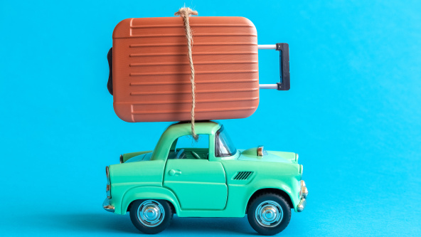 A rendered image of suitcase on car roof on blue background for a travelling to boarding school concept.