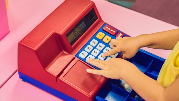 A boy plays with the children's cash register