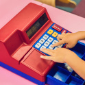 A boy plays with the children's cash register