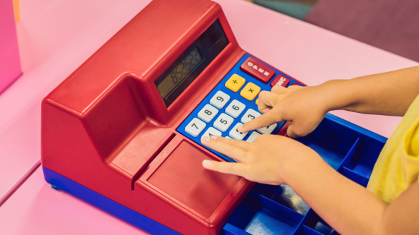 A boy plays with the children's cash register