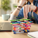 A photo of a teenager stacking pens and pencils