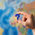 A question mark in front of a map of the world