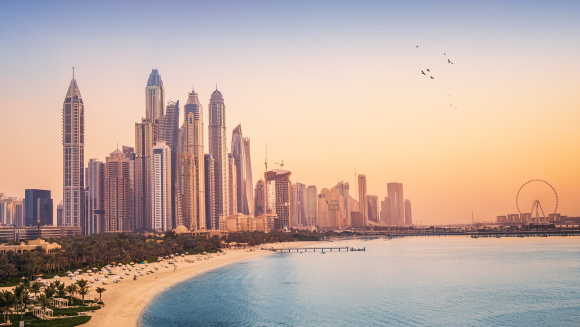 Sunset view of the Dubai Marina and JBR area and the famous Ferris Wheel and golden sand beaches in the Persian Gulf