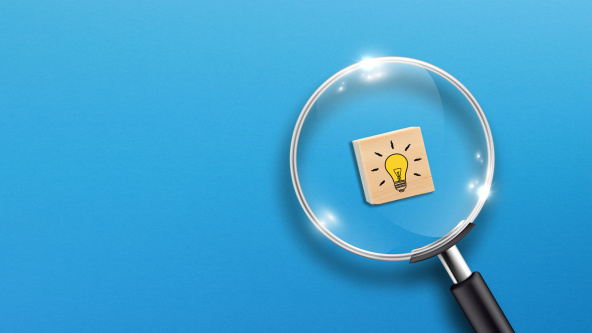 A magnifying glass over a tile with a light bulb on it