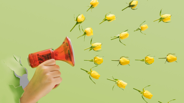 A child holding a handheld megaphone with yellow roses heads spread out in the air.