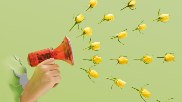 A child holding a handheld megaphone with yellow roses heads spread out in the air.