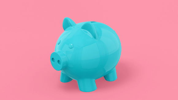 A blue piggy bank on a pink backgrounf