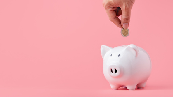 Putting a coin into a piggy bank