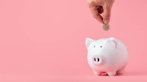 Putting a coin into a piggy bank