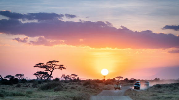 African sunset over safari vehicles in the Masai Mara, Nairobi