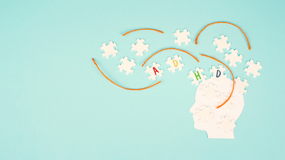 A head made from jigsaw pieces with the letters ADHD