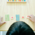 An illustration of a child learning to count with coloured sticks