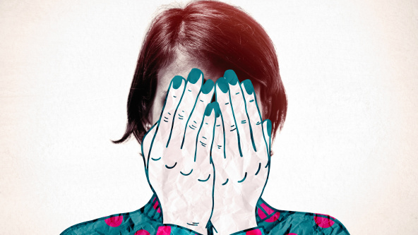 A girl holding her hands in front of her face