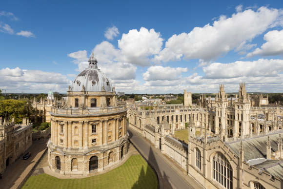 The Radcliffe Camera and All Souls College in Oxford, England. Blue, cloudy sky.