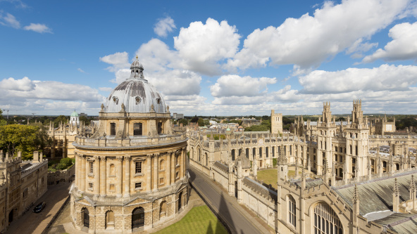 The Radcliffe Camera and All Souls College in Oxford, England. Blue, cloudy sky.