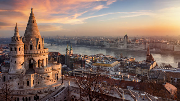 The Fisherman's Bastion from above with Hungarian Parliament building and River Danube during a golden sunrise in Budapest