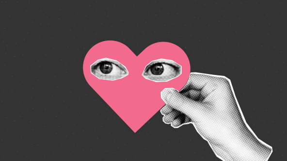 A hand holding a heart with eyes on it