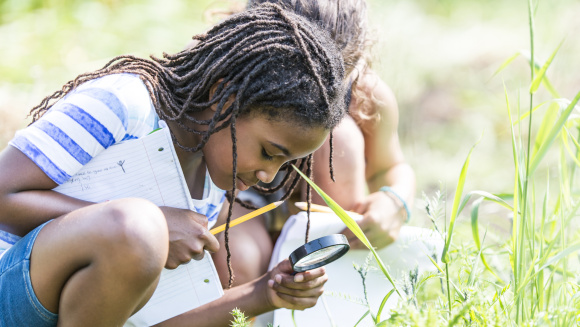 A girl at forest school looking at nature