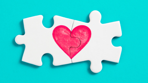 Two joined jigsaw pieces with a heart