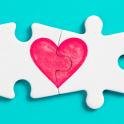 Two joined jigsaw pieces with a heart