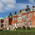 The main building of Pangbourne College with apple trees in blossom in the foreground