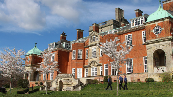 The main building of Pangbourne College with apple trees in blossom in the foreground
