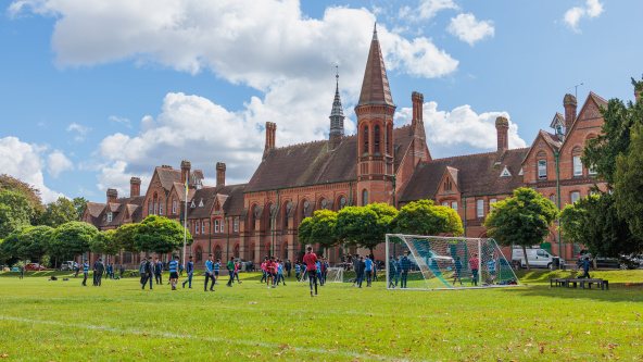 Football practice takes place in front of Reading Schools striking red-brick building