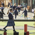 A girl in uniform walks across playground apparatus at The Study Prep, Wimbledon