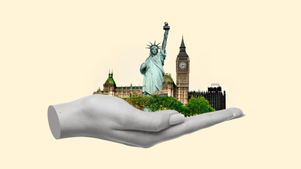 A hand holding the Statue of Liberty and Big Ben