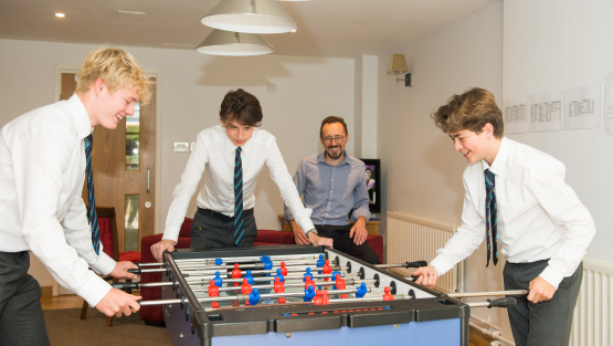 Boys in uniform play table football at Ardingly College