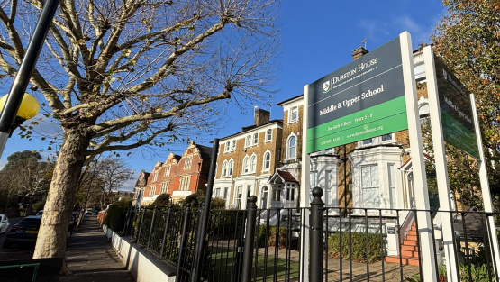 Sign of the middle and upper school of Durston House School with the school buildings behind.