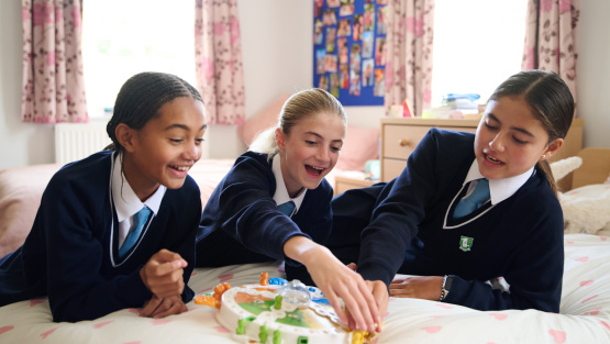 Boarders at Heathfield School play games on a bed