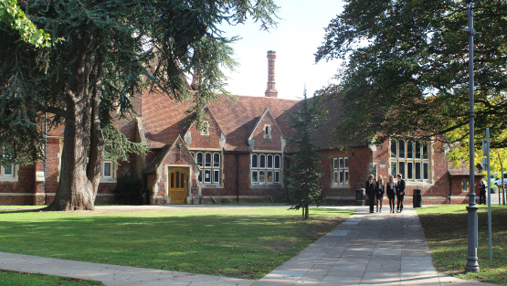 Exterior of Hockerill Anglo European College with school children surrounded by green scenery