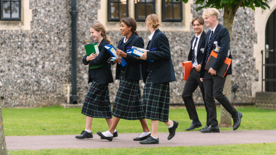 Pupils at Hurstpierpoint College carrying folders walking across school grounds