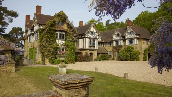 Hurtwood House main house; a mock tudor manor house hung with wisteria