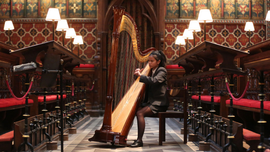 A pupil of King's School Rochester plays the harp inside Quire of Rochester Cathedral