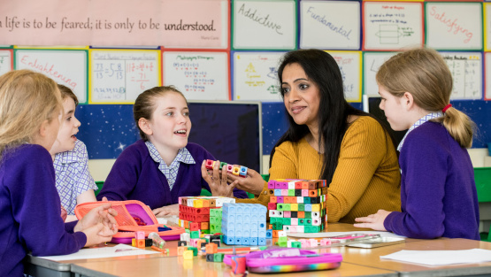 Pupils at Maltman's Green Prep sitting at classroom table talking with teacher