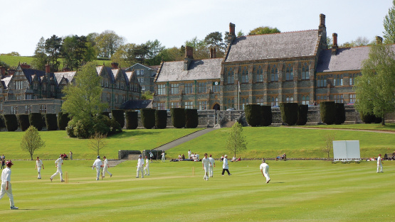 The main school buildings of Mount Kelly, viewed from a distance across a cricket field