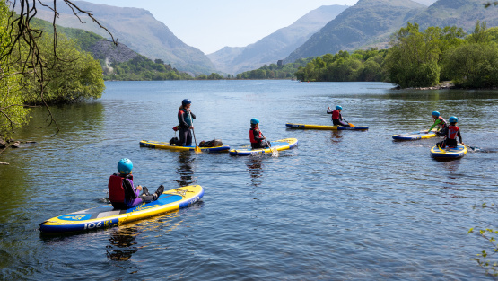 Pupils of St David's College paddle boarding on a Llyn Padarn