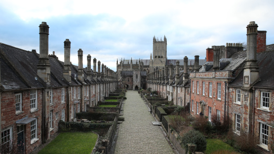 Wide angle view of cobbled medieval road, Vicar's Close, in Wells, with the Cathedral in the background